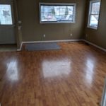 Empty room with wooden floors and windows.