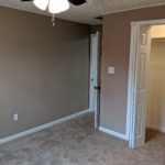 Empty room with beige walls, carpet, and a ceiling fan.