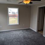 Empty room with gray carpet and beige walls.