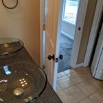 A bathroom with a glass sink and a partially open door.