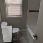 A small bathroom with a white toilet, sink, and bathtub.